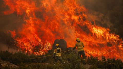 Los bomberos trabajando este domingo en la extinción del incendio forestal en el Parque Natural de Alvao, en el distrito luso de Vila Real.