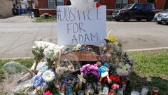 Velas, cruces y flores rodean una pancarta que pide �Justicia para Adam�