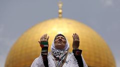 Una mujer palestina reza frente a la Cpula de la Roca