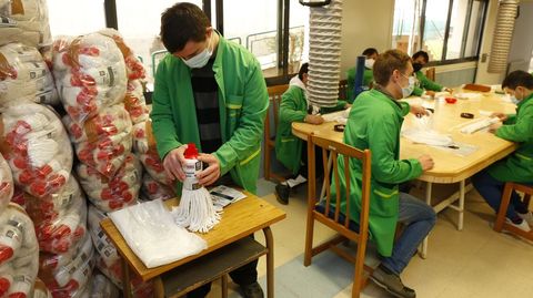 Miembros de la Fundacin Juan XXIII trabajando en uno de los talleres ocupacionales, en el que se confeccionan fregonas que luego vende Froiz.  