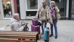 tasa.Tres turistas debatan este lunes sobre la tasa turstica junto a sus maletas, en A Corua.
