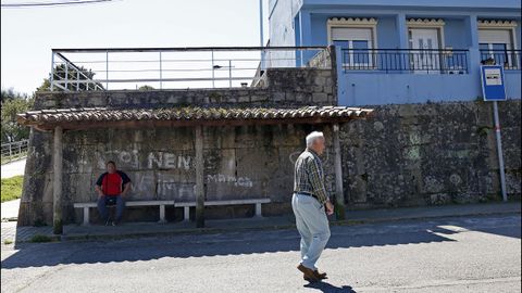 Un muro y unos bancos de piedra solo necesitan unos postes de madera y unas tejas para convertirse en una marquesina en Boiro