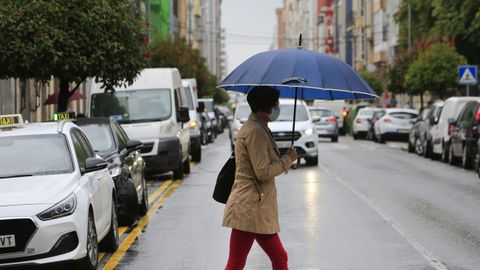 Una mujer, cruzando la cntrica Ra da Pravia en das pasados