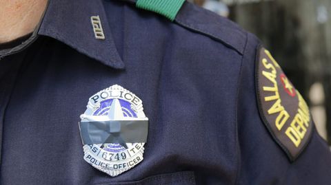 Un polic�a con una cinta negra indentificavia que participa en el rezo por las v�ctimas de la matanza en Dallas