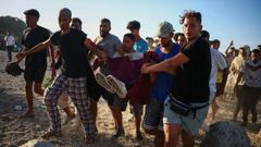 Migrantes cargan a otro migrante que result� herido.