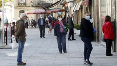 Gente con mascarillas hace cola en la calle Cardenal