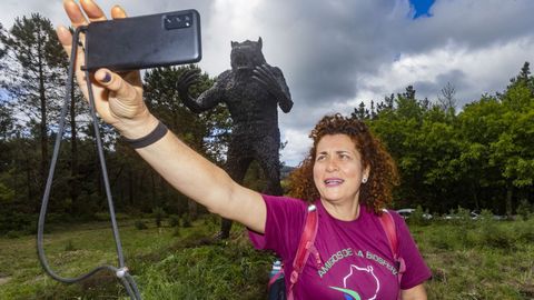 Una peregrina se hace un selfi con la imponente estatua de Vkner al fondo.