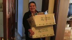 Una trabajadora del servicio, entregando la comida a uno de los beneficiarios.