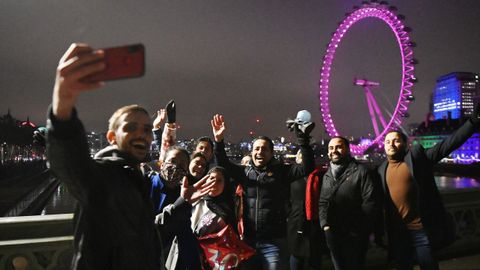 Transe�ntes se toman fotograf�as en el puente de Wensminster (Londres) para celebrar el cambio de a�o